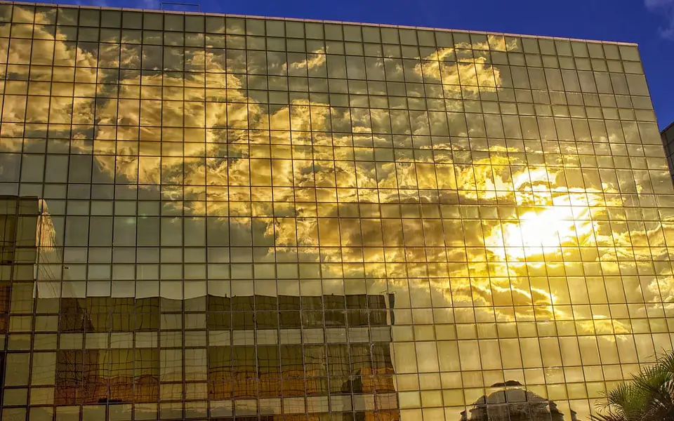 Golden glass facade of the City of Dreams resort in Manila reflecting a sunset sky