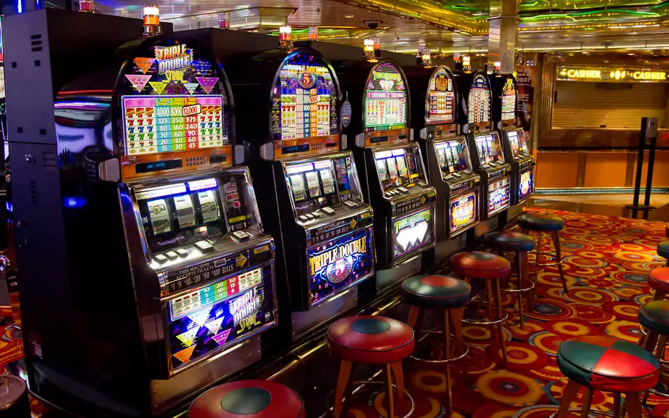 Rows of colourful slot machines with stools in a casino