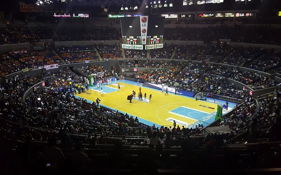 Packed basketball arena in Manila with fans in the stands and players on court